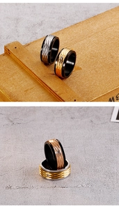 Dettaglio di anelli larghi in acciaio inossidabile nero e oro rosa con zircone