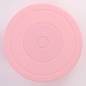 Top view of pink plastic revolving cake turntable with concentric circular patterns