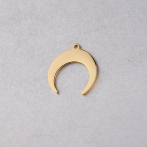 Macro detail of a golden crescent moon pendant with a smooth mirror polished finish