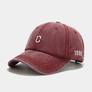 Detail of vintage washed burgundy baseball cap featuring white C embroidery and 1999 text