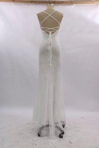 Detail view of lace embroidery and criss-cross back tie on white mermaid dress