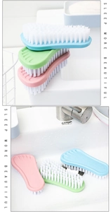 Set of 3 foot-shaped cleaning brushes with stiff white bristles in pink, blue, and green