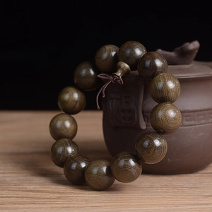 Detail of 18mm Phoebe wood beads with natural grain, 13 pieces set near a teapot