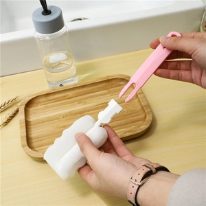 Pink long handle sponge brush for bottle cleaning assembly view on a wooden tray