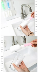 Detailed view of long handle sponge cleaning brushes in pink, green, and blue colors