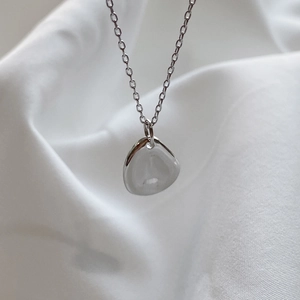 Minimalist 925 silver necklace with irregular water drop pendant on white silk fabric