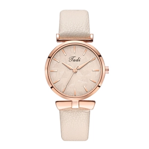 Detail of rose gold quartz watch with leaf pattern dial and beige leather strap
