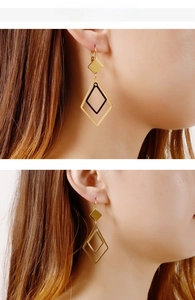 Close-up of golden geometric rhombus drop earrings worn by a model in a side view