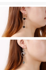 Model wearing geometric heart drop earrings in rose gold and silver finishes