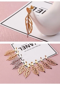 Detailed macro view of hollow leaf drop earrings in gold, silver, and rose gold finishes
