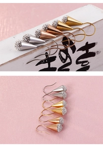 Nahaufnahme von kegelförmigen Strass-Ohrringen in Silber, Gold und Roségold aus Titanstahl