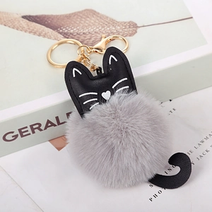 Dettaglio portachiavi gatto in PU nero con pompon grigio in finta pelliccia e gancio dorato