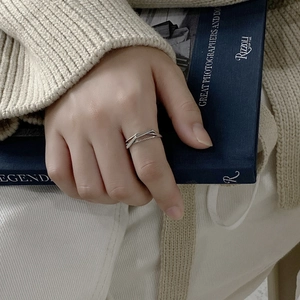 Minimalist 925 sterling silver woven heart ring styled on a model over a vintage book