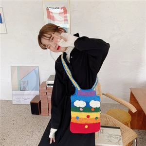 Rainbow crochet shoulder bag with cloud and raindrop details shown on a model