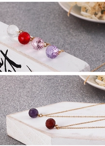 Detailed close-up of crystal gemstone necklaces in multiple colors with golden chain