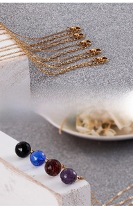 Detail of lobster clasp and faceted crystal glass beads on a gold titanium steel necklace