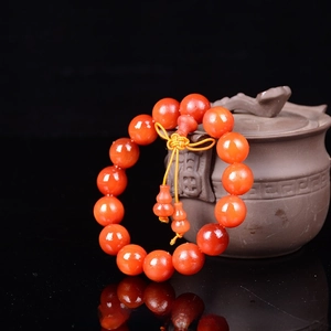 Close-up of translucent amber wood beads with 15mm diameter and a gourd charm on a pot