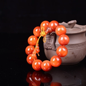 Detailed macro view of 20mm amber wood prayer beads with orange resin texture and gourd charm