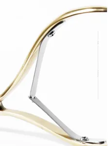 Detailed close-up of the single spring mechanism on a golden stainless steel cuticle nipper