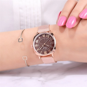 Close-up of a rose gold mesh watch with a brown Roman numeral dial and matching bracelet