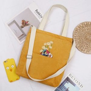 Mustard yellow corduroy tote bag with daisy embroidery and adjustable crossbody strap