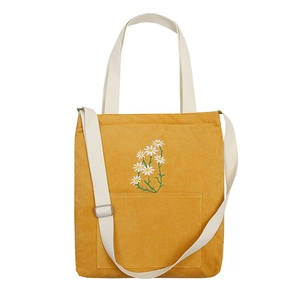 Yellow corduroy shoulder bag with daisy embroidery and adjustable strap in front view