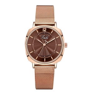 Détail de la montre à mailles or rose avec cadran brun et motifs ondulés