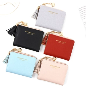 Portefeuilles femme en cinq couleurs avec pompon et breloque cœur doré sur fond blanc
