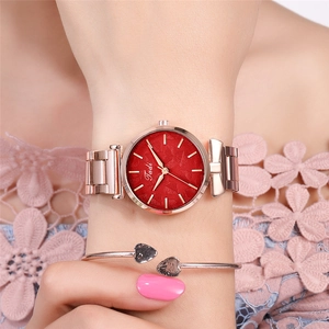 Detail of rose gold metal link strap watch with red textured dial on model wrist