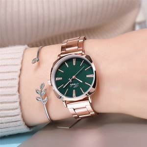 Close-up of Tadi rose gold watch with green dial and elegant leaf charm bracelet