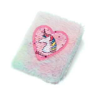 Close-up of fluffy unicorn notebook featuring sequined heart patch and colorful fur