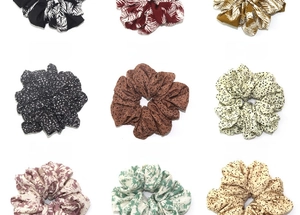 Detail view of assorted printed scrunchies in leopard, floral, and polka dot patterns