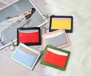 Close-up of colorful patchwork leather wallets with keychains on a textured background