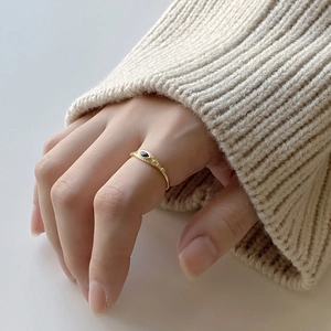 Close-up of gold 925 silver ring with marquise black stone worn with a knit sweater
