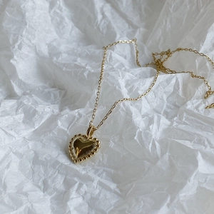 Minimalist gold 925 sterling silver heart necklace with beaded border on white background