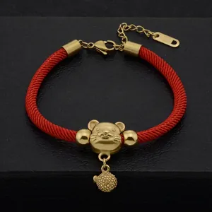 Detailed view of red woven couple bracelet with a golden zodiac mouse charm and beads
