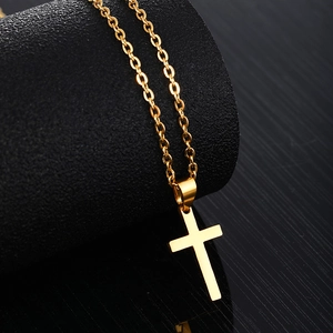 Élégant collier pendentif croix en acier inoxydable doré suspendu sur support noir