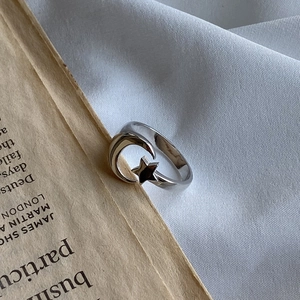 Detail of a 925 sterling silver star and moon ring on a vintage book and fabric