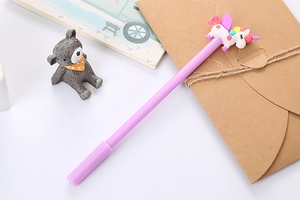 Close-up of purple unicorn pen on desktop with cute stationery and accessories