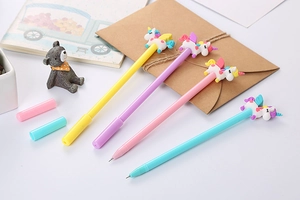 Set of four pastel unicorn gel pens in yellow, purple, pink, and blue on desk