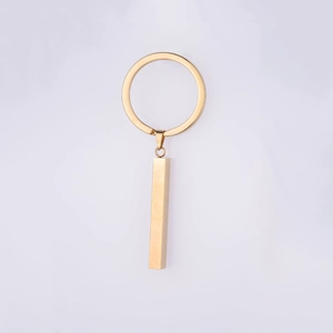 Detailed view of a golden minimalist stainless steel bar pendant on a circular keychain