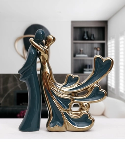 Detail of dark green ceramic couple statues with elegant gold electroplated accents