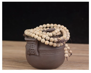 Détail macro de 108 perles en bois de camphre avec nœud traditionnel sur pot à thé