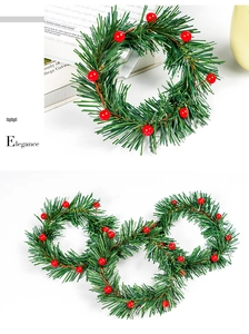 Detail view of mini Christmas wreaths with artificial pine needles and red berries