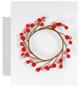 Detail view of a Christmas candle ring with vibrant red and metallic gold faux berries