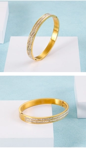 Dettaglio di un bracciale rigido dorato con doppia fila di zirconi bianchi incastonati