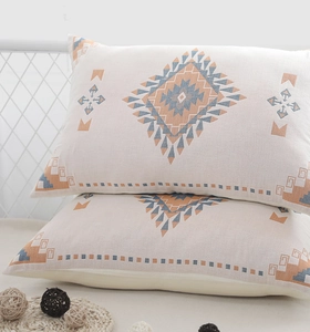 Detail of gauze cotton pillowcases with bohemian blue and orange geometric patterns