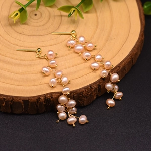 Macro view of purple freshwater pearl tassel earrings with 18k gold plating on wood