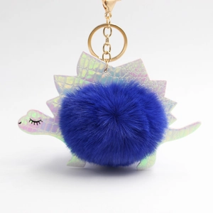 Dettaglio di un portachiavi a dinosauro blu in peluche con scaglie laser in pelle PU