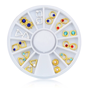 Macro view of geometric nail art studs and colorful rhinestones in a white carousel wheel